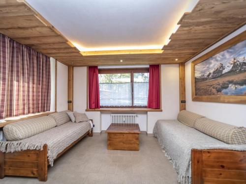 a living room with two beds and a window at Snug apartment in Sauze d Oulx with fenced garden in Sauze dʼOulx