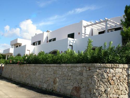 uma casa com paredes brancas e uma parede de pedra em Holiday home 400 meters from the sea near Gallipoli em Nardò