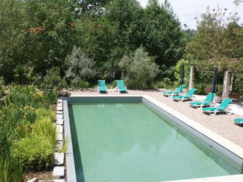 a swimming pool with lounge chairs and a group at Spacious holiday home on estate near Covas in Covas