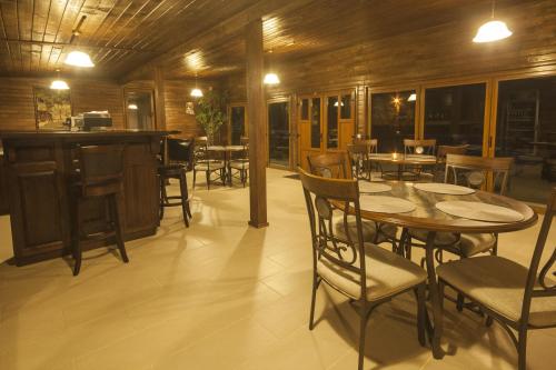 a restaurant with tables and chairs and a bar at Pensiunea Muntele Verde in Slănic