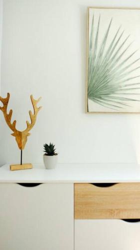 a desk with two plants and a picture on the wall at Coastal Home in Tamarin, AC, Wi-Fi, Walk to Everything in Tamarin in Tamarin