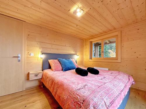 a bedroom with a bed in a wooden cabin at Chalet a Didi - Alps Paradise - 4 Vallees in La Tzoumaz