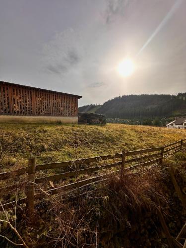 a fence in a field next to a barn at Zaporizʹka Sich in Bukovel