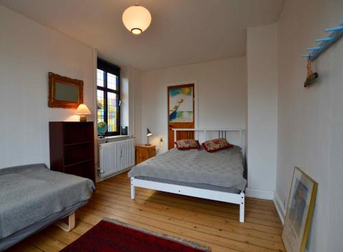 1 dormitorio con 2 camas y ventana en Charmerende Lejlighed I Stege Midtby, en Stege