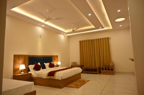 1 dormitorio con 1 cama grande y techo en Shiva Palace by Golden Leaf Hotels, en Haldwāni