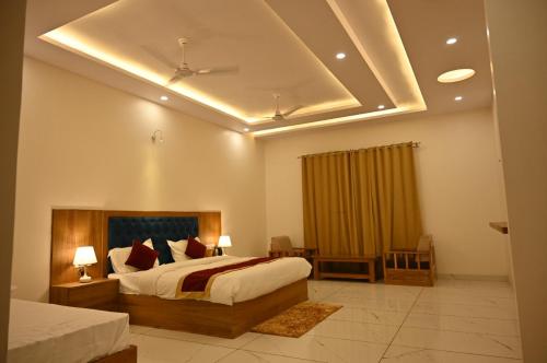 1 dormitorio con 1 cama grande y techo en Shiva Palace by Golden Leaf Hotels en Haldwāni