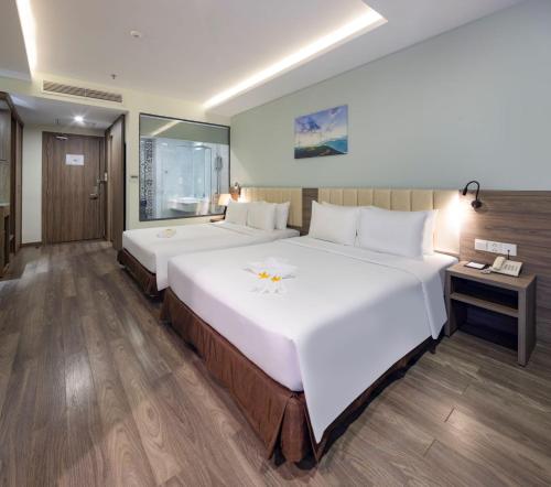 a large white bed in a hotel room at Xavia Hotel in Nha Trang