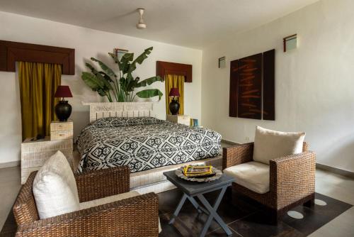 a bedroom with a bed and two chairs and a table at Casa Vagator in Vagator