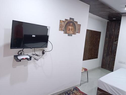 a room with a tv on a white wall at Hotel Balaji Residency in Udaipur
