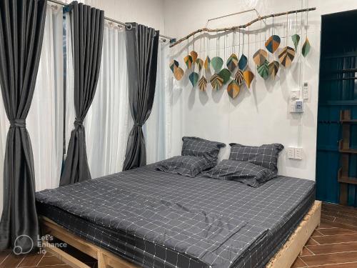 a bed in a room with black curtains at VulunVili Homestay in Tây Ninh