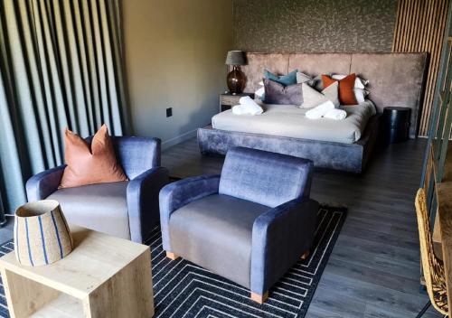 a living room with a bed and a couch and chairs at Walkersons 96 - NinetySix on Valley View in Dullstroom