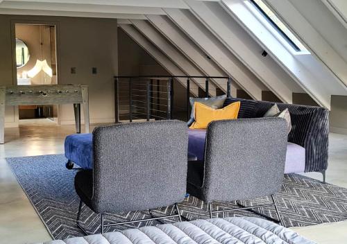a bedroom with a bed with two chairs and a table at Walkersons 96 - NinetySix on Valley View in Dullstroom