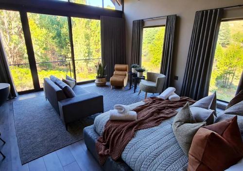 a bedroom with a large bed and a living room at Walkersons 96 - NinetySix on Valley View in Dullstroom