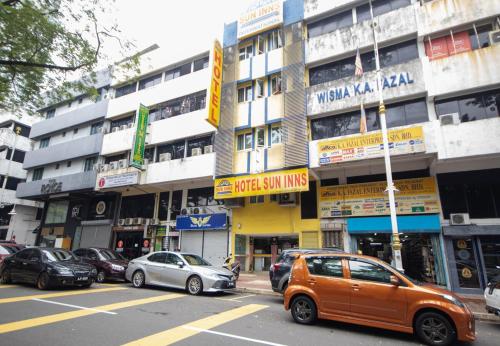 un'auto arancione parcheggiata di fronte a un edificio di Sun Inns Hotel Sentral, Brickfields a Kuala Lumpur