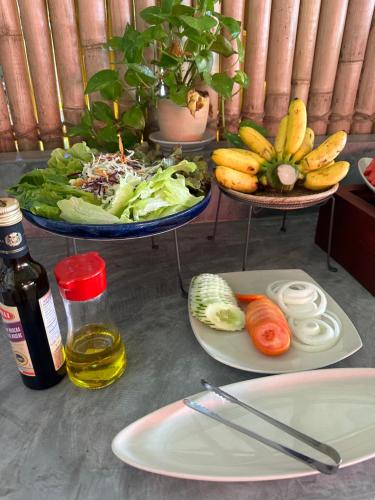 two plates of food with vegetables and a bottle of wine at Noble House Beach Resort in Ko Lanta