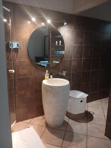 a bathroom with a sink and a mirror at Africa Dawn Guesthouse in Musina