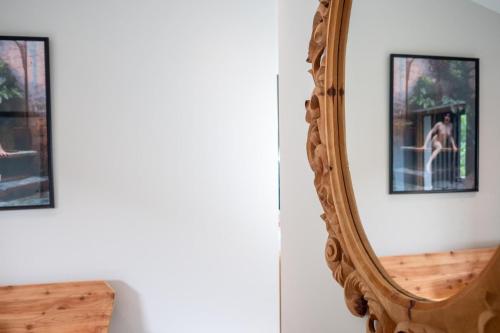 a mirror hanging on a wall with two pictures at Alte Bildhauerei in Aurach bei Kitzbuhel