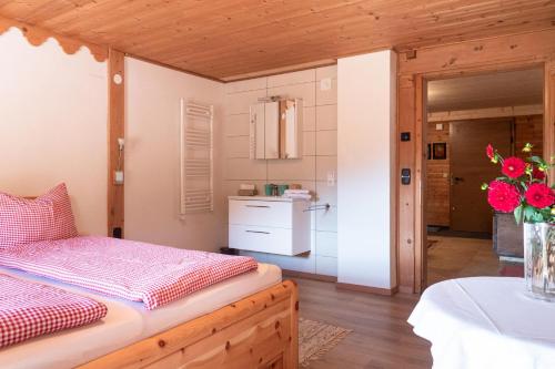 a bedroom with a bed with a vase of flowers at Alte Bildhauerei in Aurach bei Kitzbuhel