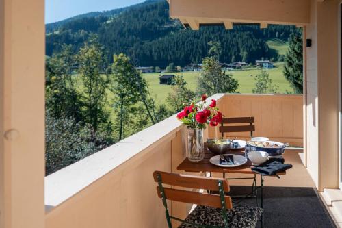 a balcony with a table with flowers on it at Alte Bildhauerei in Aurach bei Kitzbuhel
