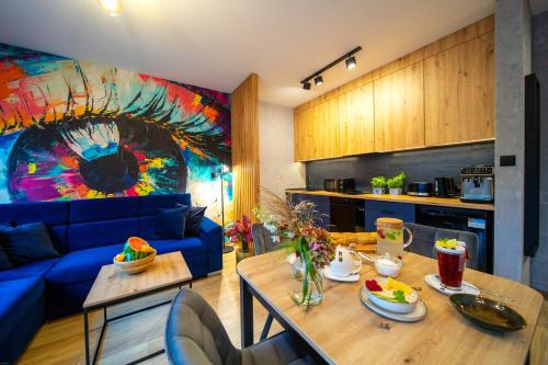 a living room with a blue couch and a table at Błaż Apart in Laskowa