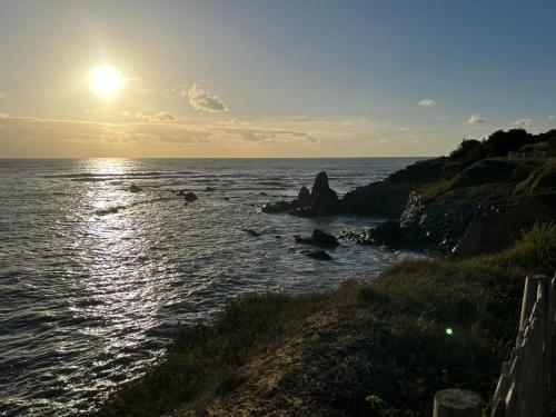 a person sitting on the shore of a body of water at La Petite Marine a 150m de la plage in Brétignolles-sur-Mer