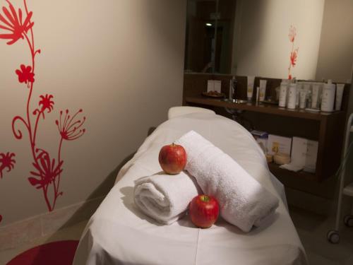 two apples sitting on top of towels on a bed at Hotel Spa Attica21 Vilalba in Villalba
