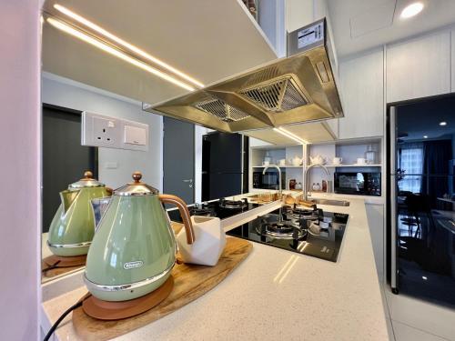 a kitchen with two green vases on a counter at Gaia Residence, Gamuda Gardens Rawang by Sleepy Bear in Kuala Lumpur