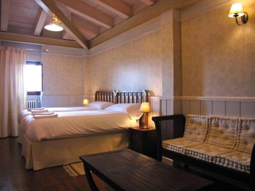 Casa Rural Negua en La Cuenca, Soria في La Cuenca: غرفة نوم بسرير واريكة وطاولة