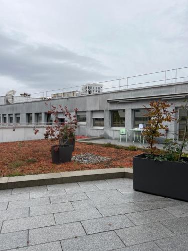 um edifício com dois vasos de plantas em frente em LivingTown em Zurique