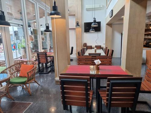 a restaurant with wooden tables and chairs and a table at P168 Hostel Samui in Chaweng