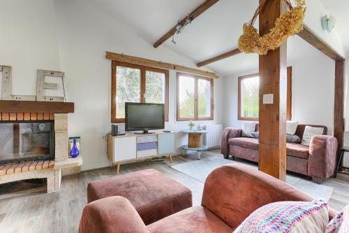 a living room with a fireplace and a tv at La Cabanette à 10min de Disneyland Paris - Cabane & Cabanon in Chalifert