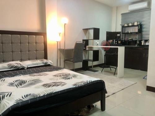 een slaapkamer met een bed, een bureau en een keuken bij JMC Homes in Manilla