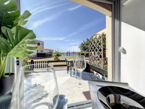 d'une terrasse avec une table en verre et des chaises sur un balcon. dans l'établissement Studio Prestige avec terrasse, île des pêcheurs, Vue port, au Cap d'Agde