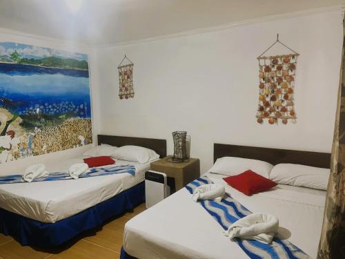 a room with two beds and a painting on the wall at Malapascua Beach and Dive Resort in Logon
