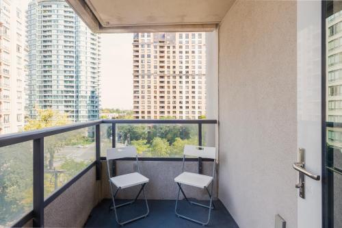 two chairs on a balcony in a building with tall buildings at Near Yonge Finch Subway 2Bed 2Bath Condo Free Parking in Toronto