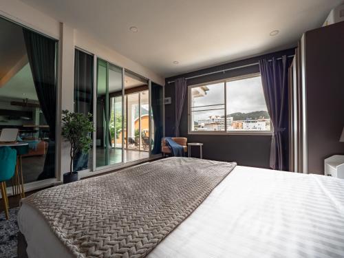 ein Schlafzimmer mit einem großen Bett und einem großen Fenster in der Unterkunft Grand Penthouse by Grand Orlov Apart in Patong Beach