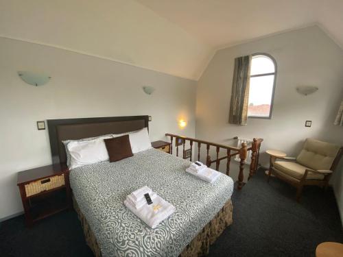 een slaapkamer met een bed met twee handdoeken erop bij Ace Motor Lodge in Rotorua
