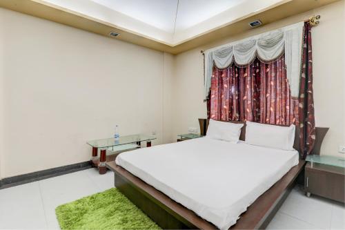 1 dormitorio con cama y ventana en OYO Hotel M & c, en Patna