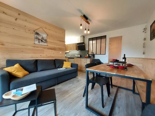 un salon avec un canapé bleu et une table dans l'établissement Villard je t'aime - Résidence Les Tennis - 2 Appartements 2 pièces 5 p et 6 p, à Villard-de-Lans