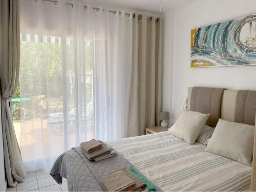 a bedroom with a bed in front of a window at Coral House - La Calma - Playa Flamenca - big terrace & 4 Swimming pools. in Playa Flamenca