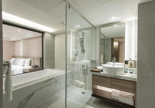 a bathroom with a tub and a sink and a shower at Spring Rhapsody Hotel in Taichung