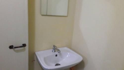 a bathroom with a white sink and a mirror at ทรัพย์ทอง การ์เด้น รีสอร์ท in Khao Kho