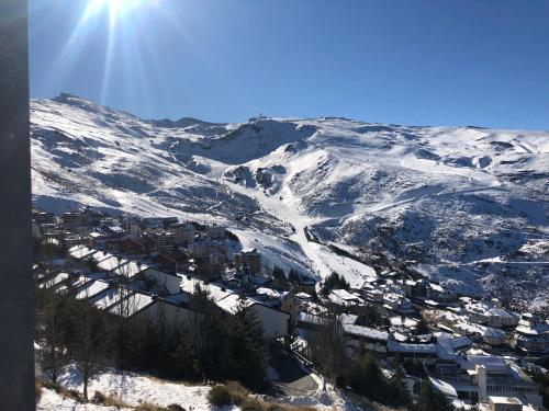 een met sneeuw bedekte berg met een stad op de voorgrond bij Europa premium in Sierra Nevada