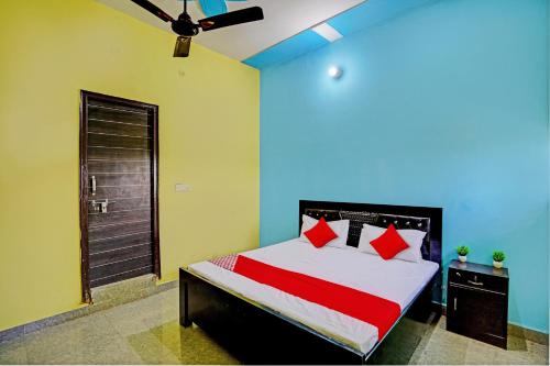 a bedroom with a bed with red pillows at OYO Flagship Midtown Guesthouse in Jhājhar