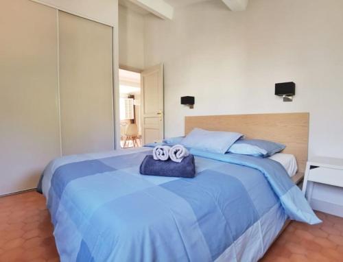 - un lit bleu avec 2 serviettes dans l'établissement Trés bel appartement centre ville historique, à Aix-en-Provence
