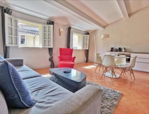 un salon avec un canapé et des chaises rouges dans l'établissement Trés bel appartement centre ville historique, à Aix-en-Provence