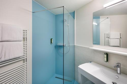 a bathroom with a glass shower and a sink at Hotel an der Reuss in Gisikon