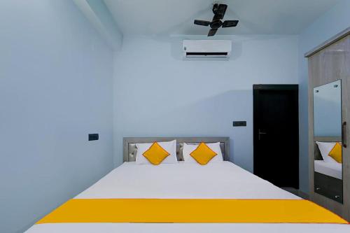 1 dormitorio con 1 cama grande con almohadas amarillas en FabExpress JT Complex en Ranchi