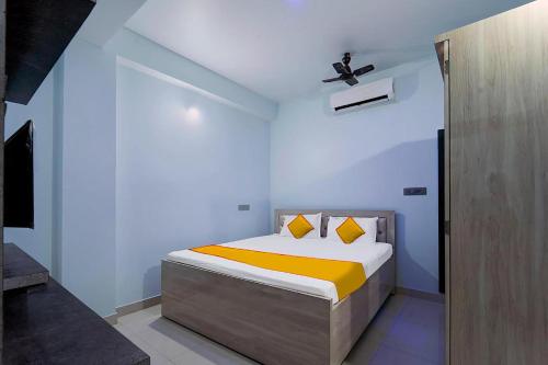 a bedroom with a bed with yellow sheets and a ceiling at FabExpress JT Complex in Rānchī