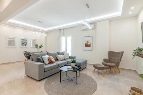 a living room with a couch and a table and chairs at Kappa Apartment in Heraklio Town